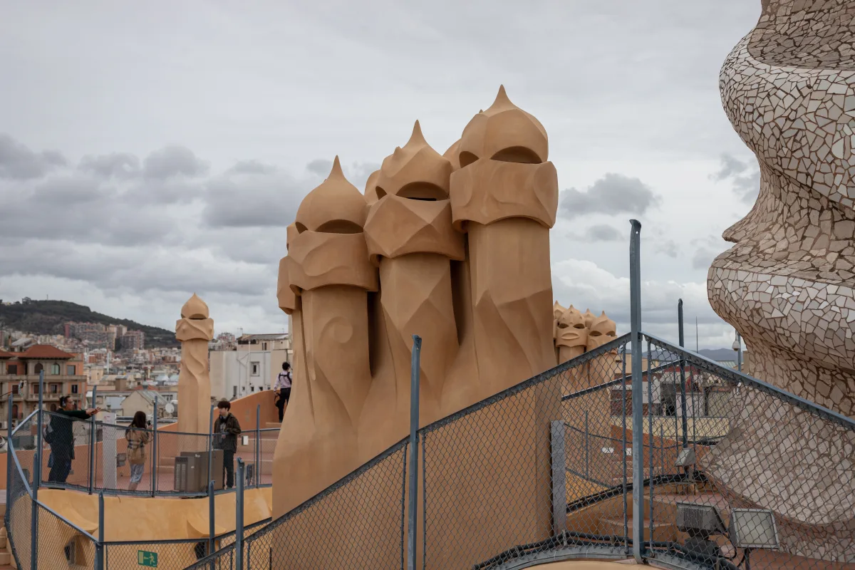 Die helmartigen Kaminskulpturen auf dem Dach der Casa Milà über den Dächern Barcelonas