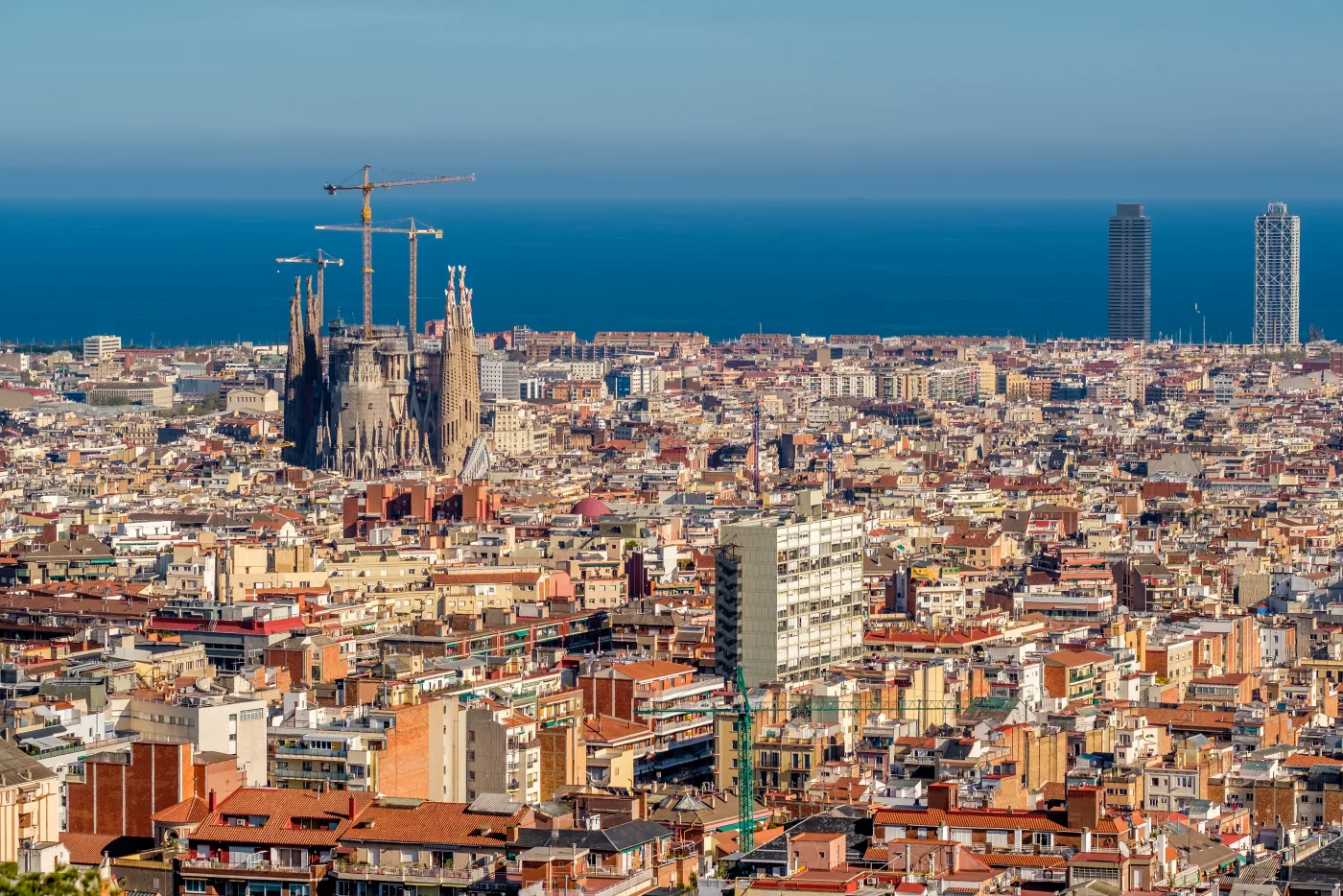 Blick über Barcelona mit der Sagrada Família, dem Häuserraster des Eixample und dem Mittelmeer