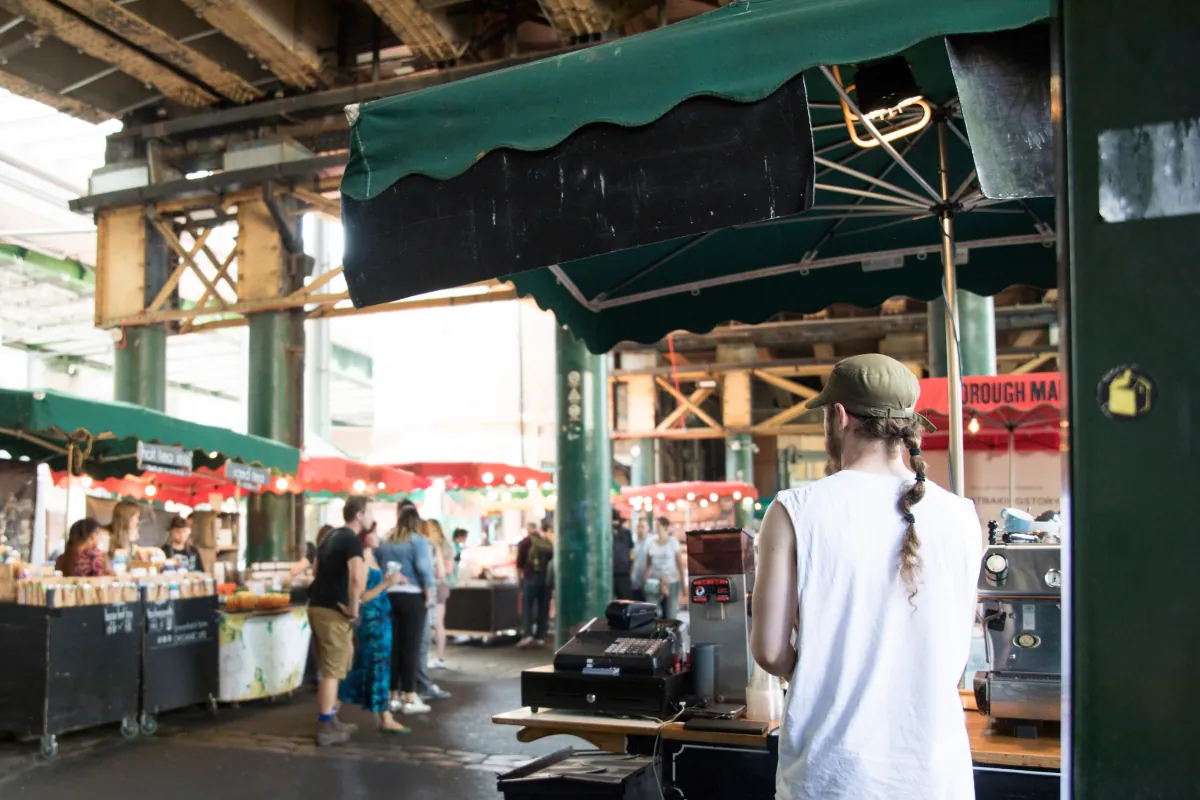 Stände mit Lebensmitteln und Getränken in einer überdachten Londoner Markthalle
