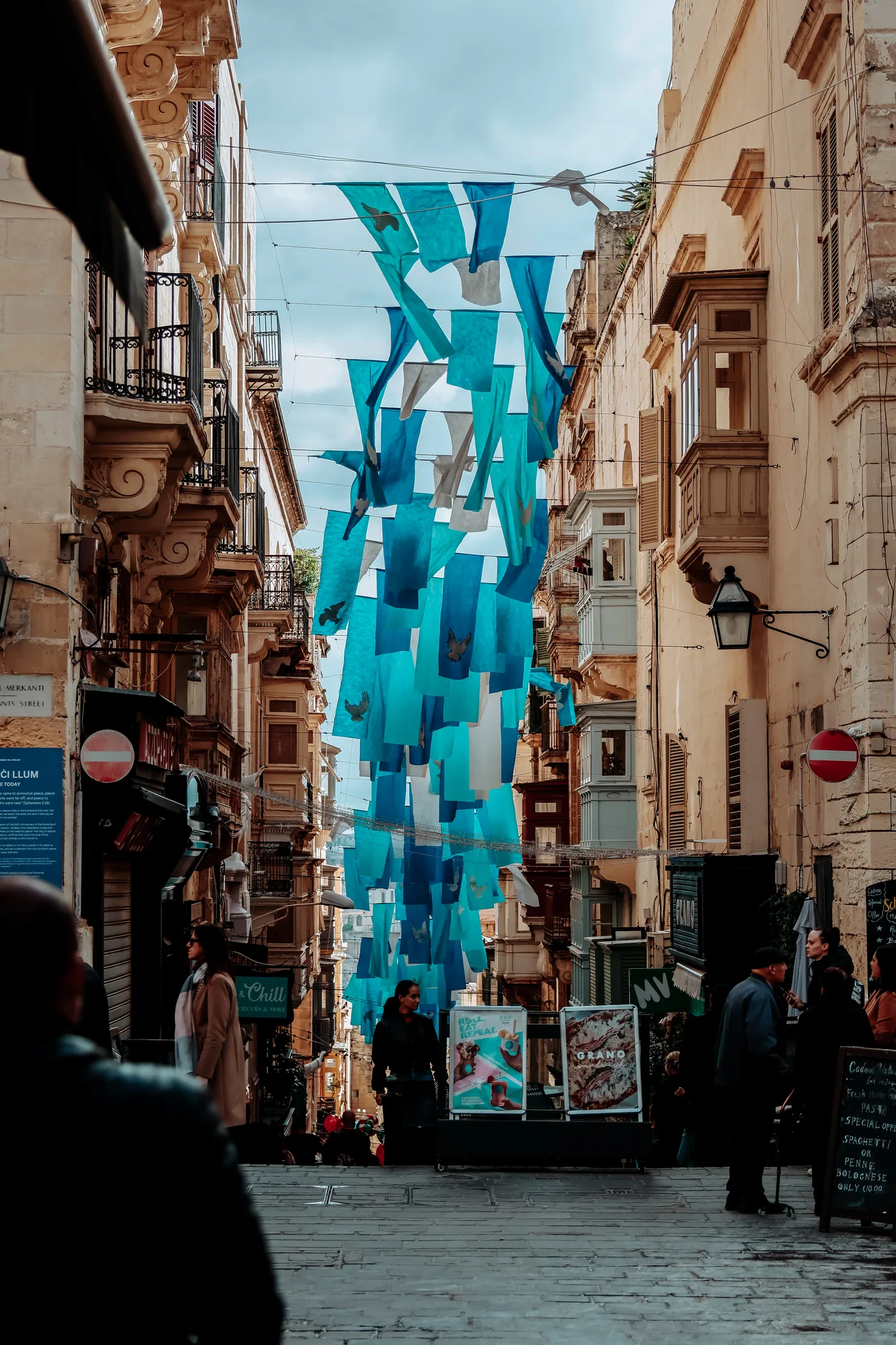 Rote Telefonzelle vor Sandsteinmauer in Mdina