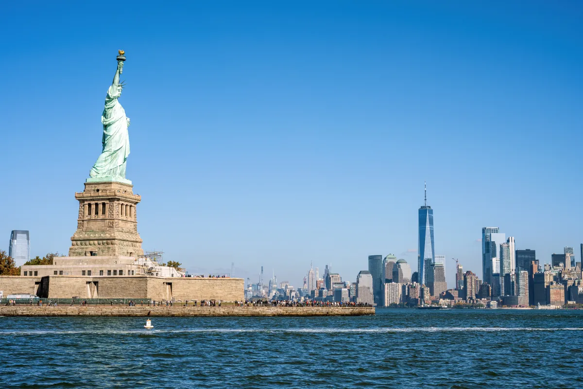 Die Freiheitsstatue auf Liberty Island, dahinter die Hochhäuser von Lower Manhattan