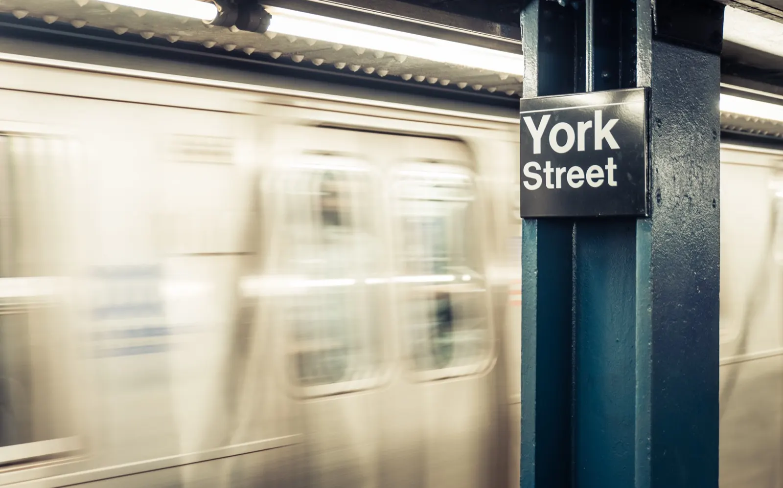 U-Bahn-Station York Street in New York mit einfahrendem Zug in Bewegungsunschärfe