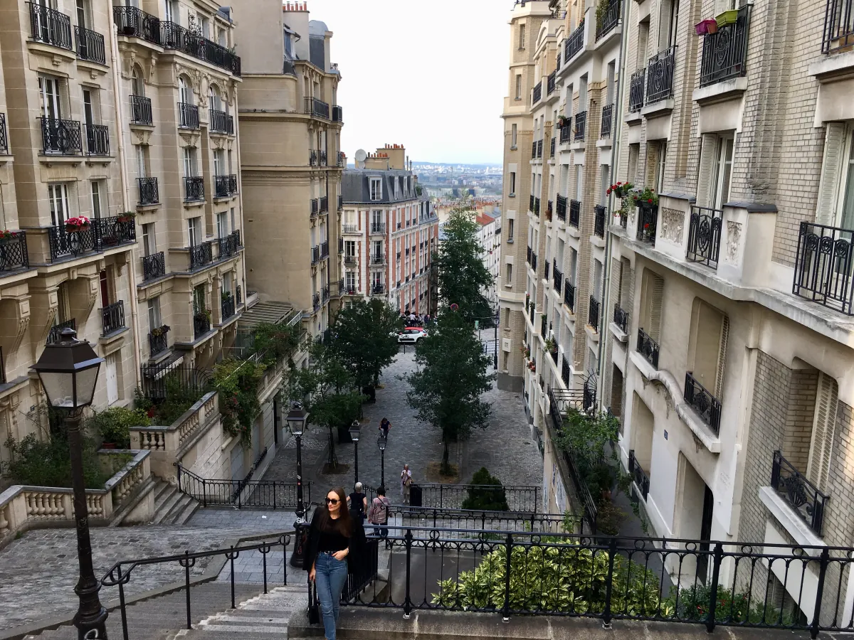 Eine Treppenstraße in Montmartre zwischen Pariser Wohnhäusern, mit Blick über die Stadt