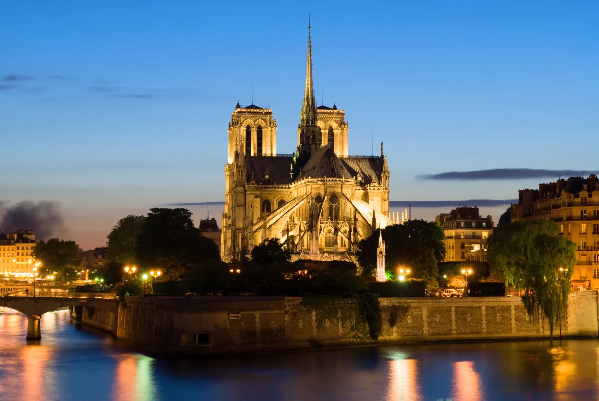 Notre-Dame de Paris zur blauen Stunde von der Seine aus, beleuchtet und im Wasser gespiegelt