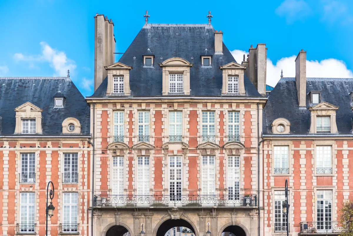 Die Backstein- und Sandsteinfassade eines Pavillons an der Place des Vosges im Marais