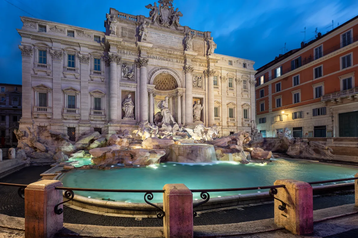 Der beleuchtete Trevi-Brunnen bei Nacht mit türkis leuchtendem Becken